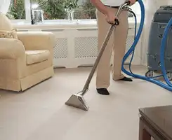 Carpet cleaning professional removing dirt and stains with a hot-water extraction tool in a home, Kansas City, KS.